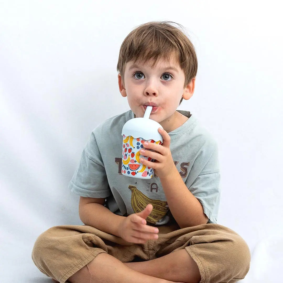 young boy holding reusable fruit smoothie cup