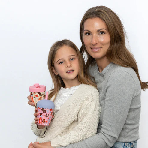 Woman and young girl holding colorful cups against a white background