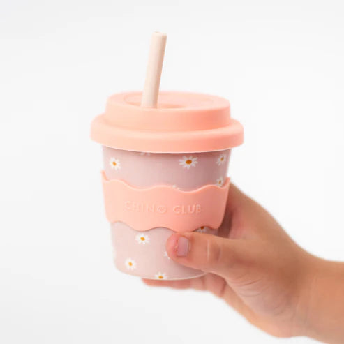 toddler holding daisy babychino cup with straw