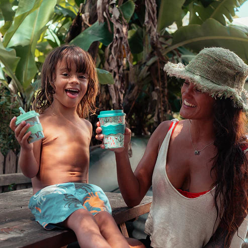 Toddler holding babychino cup with matching adult cup