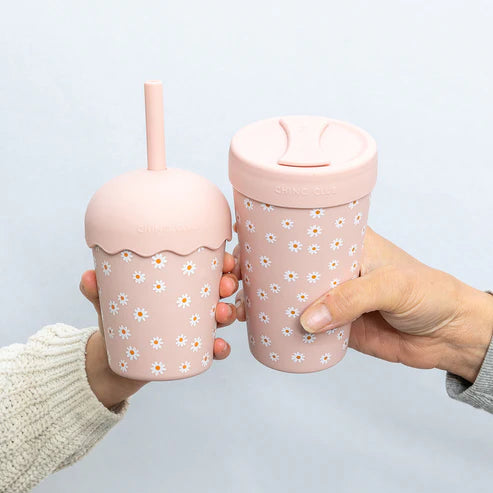Pink daisy smoothie cup with straw and 12oz chino cup for adult being held