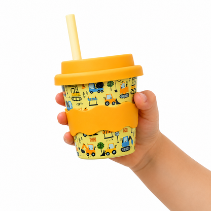 arm holding 4oz babychino cup with tractors and diggers