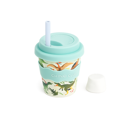 CHINO CLUB Dinosaur 4oz reusable babychino cup featuring a playful dinosaur print, food-safe silicone lid and sleeve, reusable stopper straw and matching straw cap. Perfect for babychinos, milk and little hands